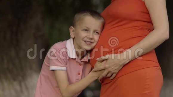 儿子听着孕妈肚子欣然惊讶充满了惊喜和积极的情绪视频的预览图