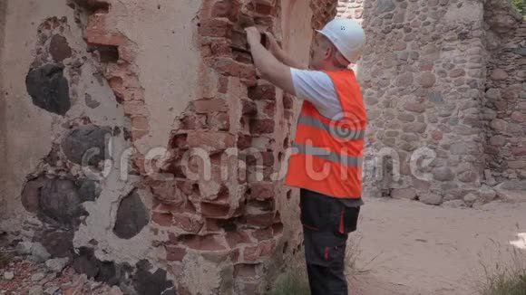 建筑工人在修复前检查旧城堡墙视频的预览图