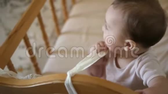 小可爱坐在婴儿床上快乐童年概念视频的预览图