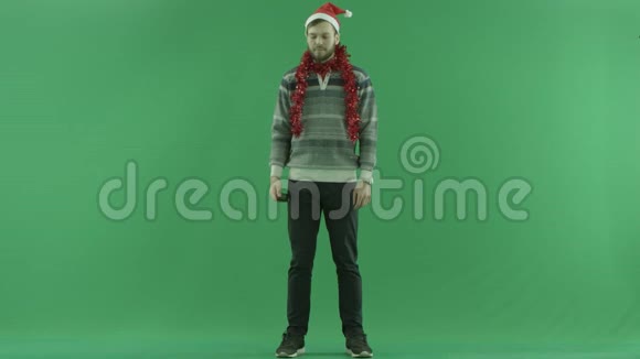 年轻的大胡子快乐的男人在圣诞节谈论智能手机绿色的关键背景视频的预览图