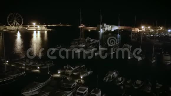 4k夜升空中无人机帆船港口和沿海城镇的镜头视频的预览图