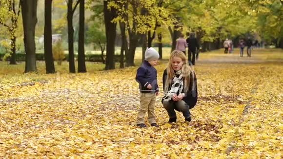 母子俩在秋日公园散步慢动作视频的预览图