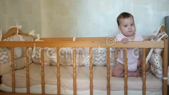 小可爱坐在婴儿床上快乐童年概念视频的预览图