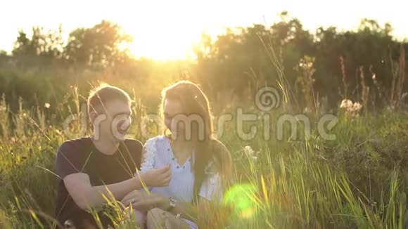 两个人在日落时相爱男人和女人在野外接吻视频的预览图