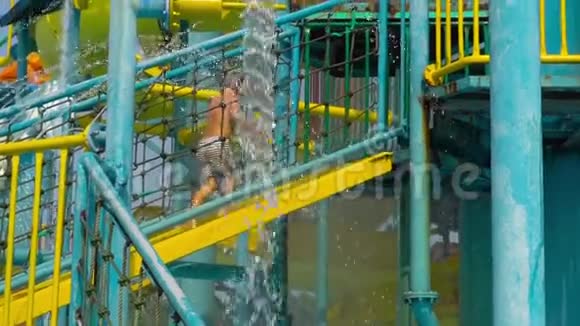 一个小男孩从楼梯上爬升到水中的一个高水位滑水开始的最高镜头视频的预览图