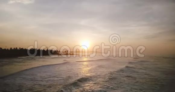 在史诗般的日落海洋海岸线上空盘旋的无人机令人惊叹的空中海浪全景到达热带海岸视频的预览图