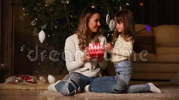 妈妈拿着礼物摇着盒子听什么令人印象深刻她的小女儿打开礼物视频的预览图