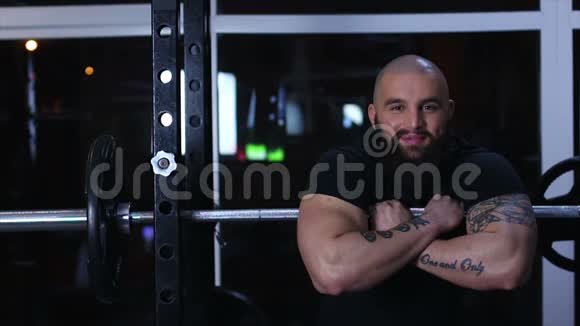 成功的男人肌肉发达的手臂对着镜头微笑促进运动生活方式视频的预览图