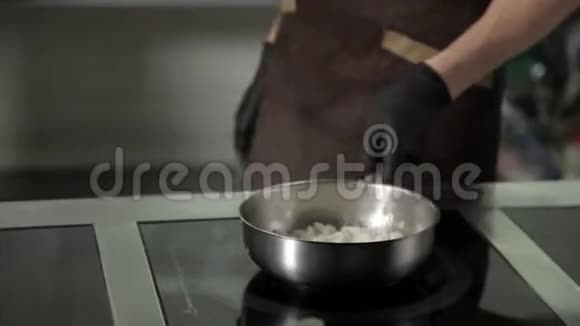 厨师在餐厅的厨房里加热一个煎锅视频的预览图