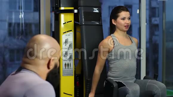 美丽的女性做腿部运动在健身房锻炼时调情视频的预览图