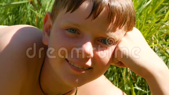 夏天在河里游泳后可爱的红发少年的肖像有雀斑和蓝眼睛的少年男孩视频的预览图