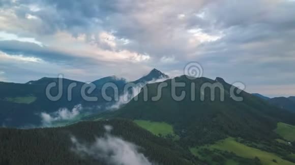 空中俯瞰绿色森林景观与快速移动的陆地越过山脉视频的预览图
