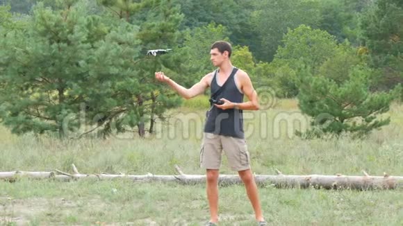 可爱的高个子男子发射并持有无人机或四架直升机在森林视频的预览图