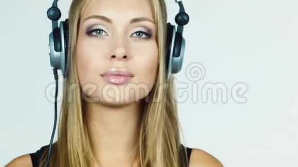 金发女孩听着耳机里的音乐紧张地跳舞视频的预览图