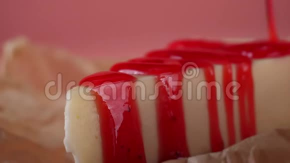 用薄薄的草莓果酱倒入美味的芝士蛋糕框架孤立于粉红色视频的预览图