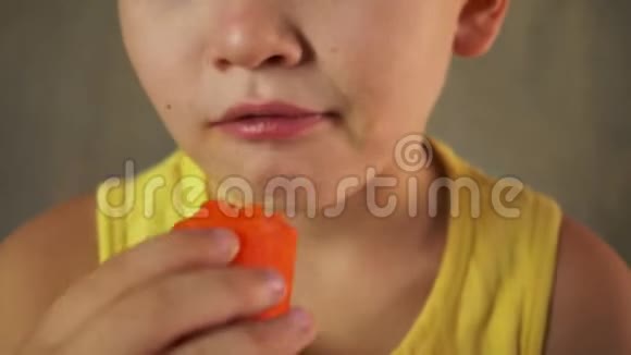有剃头的可爱孩子正在吃生胡萝卜以增强视力美味的素食视频的预览图