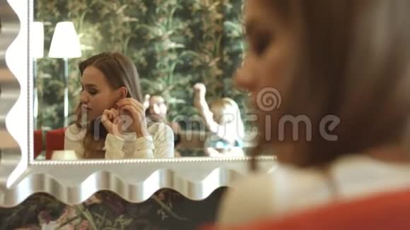 美丽的女人在镜子前检查她的外表视频的预览图