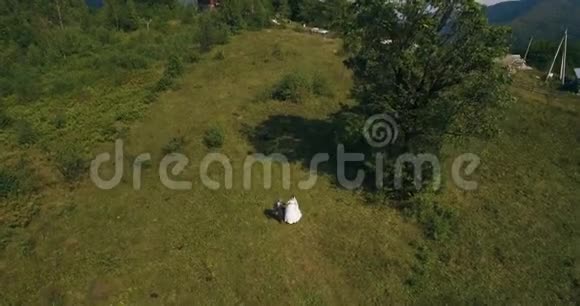 这对夫妇站在日出时风景如画的山上天空中有4K的天空视频的预览图