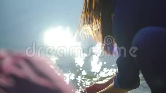 青年男女在河中洗手在山的背景上喷洒把女人的手关在水里视频的预览图