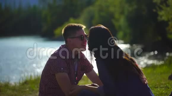 在河边的森林里野餐时一男一女在吃西瓜和接吻视频的预览图