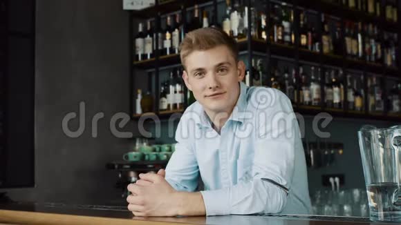 柜台后面一个快乐的年轻酒保的画像视频的预览图