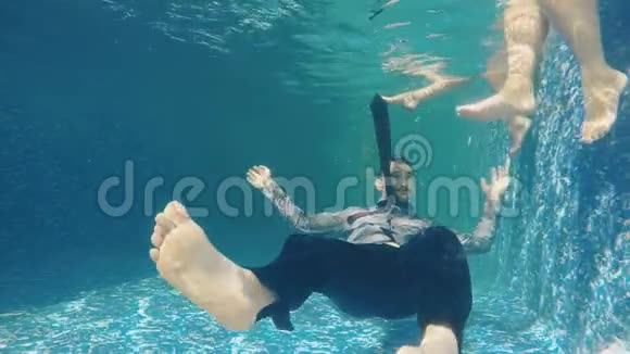 穿西装的男人在水中竖起大拇指靠近移动的女性腿视频的预览图