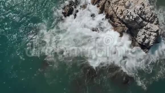 当海浪撞击岩石时开始飞行的鸟的空中视野视频的预览图