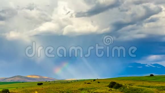 彩虹在乌云的背景下在阳光下发光太阳的影子沿着麦田移动视频的预览图