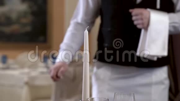 服务员的特写在优雅的餐厅里点燃蜡烛注意力集中在蜡烛上浪漫的晚餐概念视频的预览图