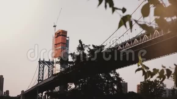 美丽的低角度视角曼哈顿桥在纽约树木和摩天大楼在建设背景4K视频的预览图