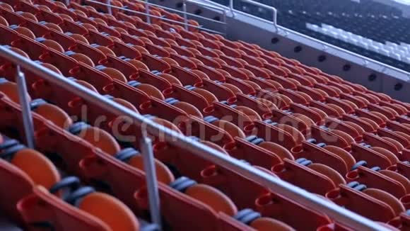 体育场竞技场座椅一排排橙色观众坐在体育场里视频的预览图