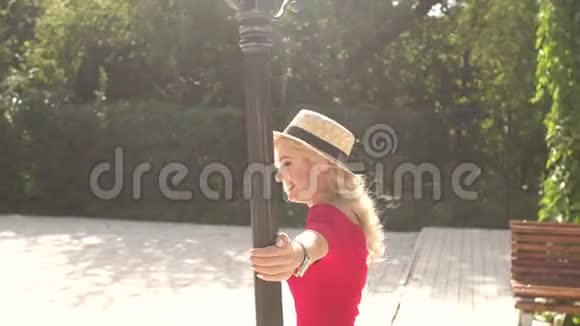 穿着红裙子在灯柱上转悠的快乐女孩视频的预览图