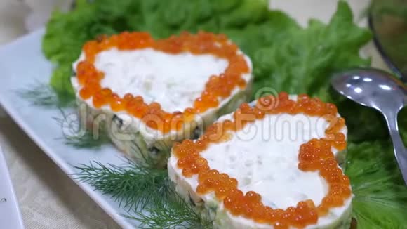 三明治带有心形的红色鱼子酱盘子和沙拉片上有鳃节日餐桌视频的预览图