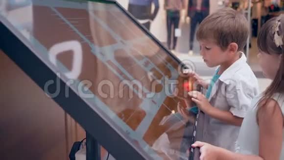 自助服务中的新技术有女朋友的小男孩使用触摸亭查询有关视频的预览图