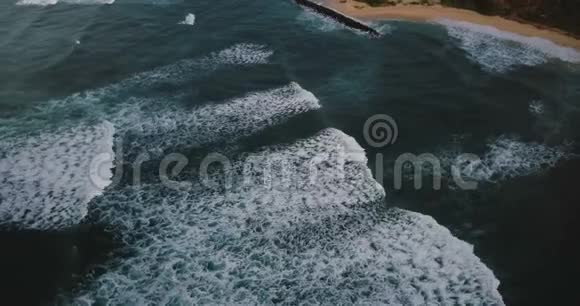 无人驾驶飞机飞过史诗般的泡沫巨浪抵达海岸蓝色海洋和海滩的惊人鸟瞰视频的预览图