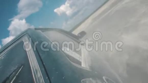 从黑色俄罗斯汽车侧面近景在沙质的地面上在蓝色多云的天空下行驶录像赛马比赛视频的预览图