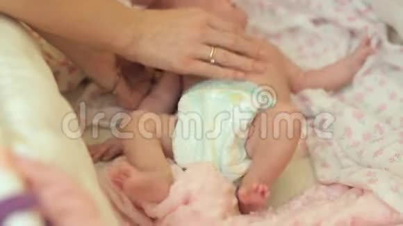 妈妈在婴儿的竞技场上触摸卧铺婴儿在母亲的抚摸下扭动身体视频的预览图