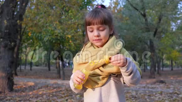 快乐的女孩喜欢在背景树上的摄像机中缓慢地做泡泡视频的预览图