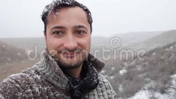 成年男子雪落时微笑视频的预览图