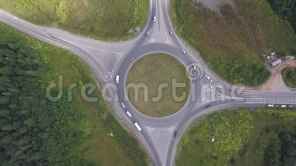 环形交叉路口的空中视野靠近森林的汽车移动剪辑国别轨道视频的预览图