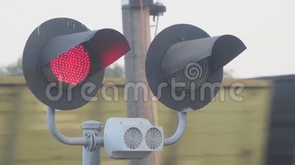 在经过的火车背景下在铁路十字路口亮起红灯视频的预览图