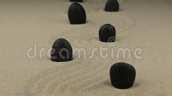 放大黑色的石头躺在沙上曲折视频的预览图