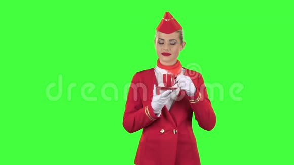 戴手套的女服务员用红色杯子喝咖啡绿色屏幕视频的预览图