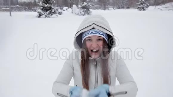 小女孩在冬天和雪地里快乐在冬天的公园里玩耍视频的预览图