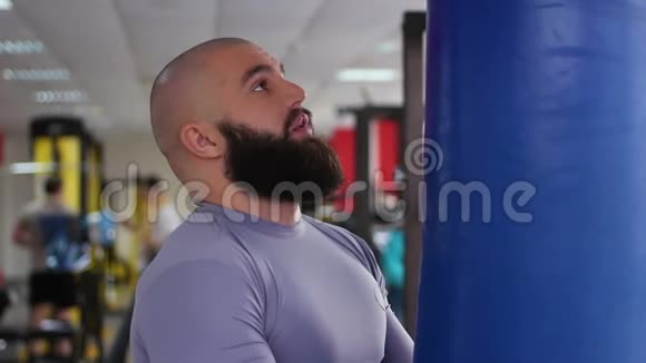 职业男拳击手在拳击袋上练习拳打脚踢在健身房努力工作视频的预览图