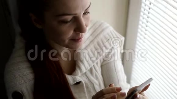 数字技术和通信中年妇女在智能手机屏幕上浏览互联网网站坐在旁边视频的预览图