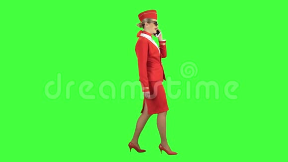 女乘务员在电话上讲话向远处走去绿色屏幕侧视图视频的预览图