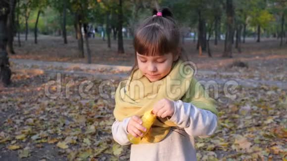 快乐的孩子戴着围巾吹着肥皂泡在公园的户外拍照视频的预览图