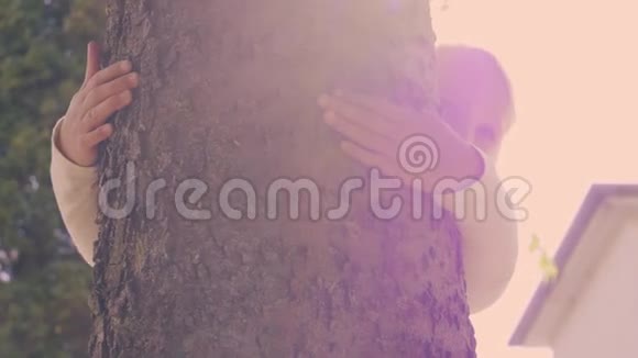 可爱的小女孩抱着一棵树视频的预览图
