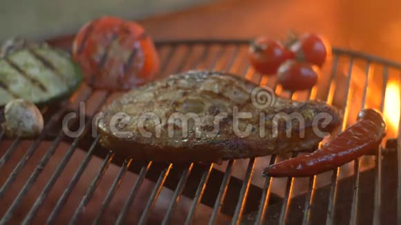 在烤菜背景和火焰上烤鱼烤牛排视频的预览图